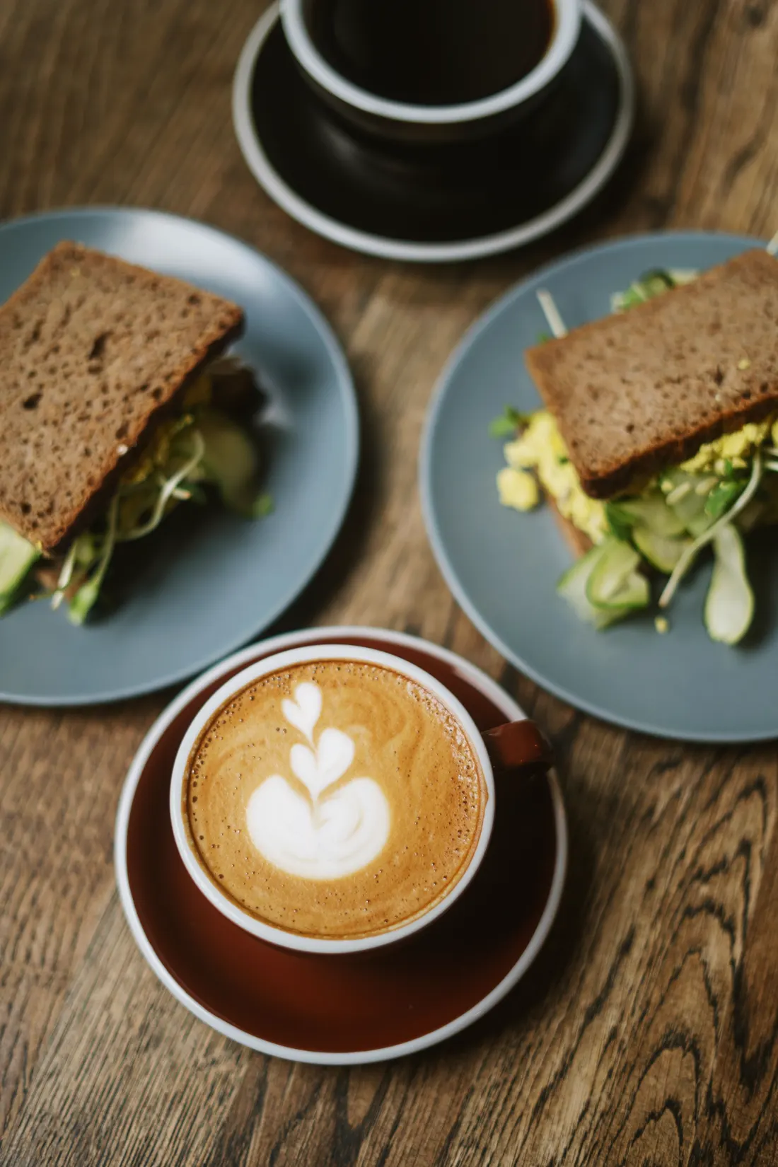 Sándwiches y café sobre una mesa de madera (imagen ilustrativa)