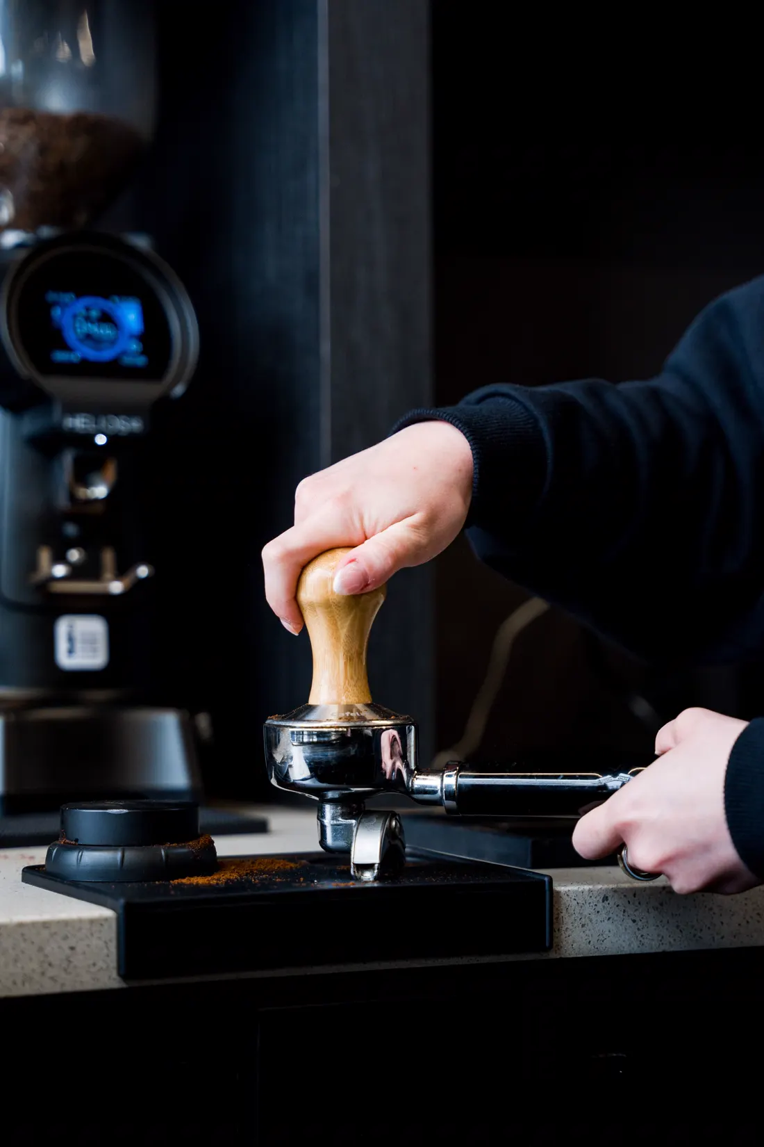 Barista presionando el café molido en el portafiltro (imagen ilustrativa)